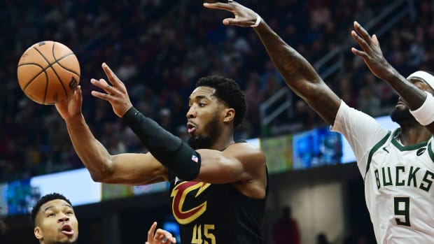 Dec 29, 2023; Cleveland, Ohio, USA; Cleveland Cavaliers guard Donovan Mitchell (45) passes as Milwaukee Bucks forward Giannis Antetokounmpo (34) and forward Bobby Portis (9) defend during the first half at Rocket Mortgage FieldHouse.